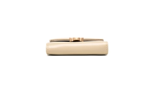 Detail view of the side profile and golden buckle of a beige leather tri-fold wallet