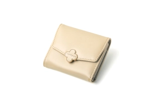 Detail shot of a cream tri-fold wallet with a gold clover clasp and fine stitching