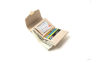 Detail of beige trifold wallet featuring multiple card slots and heart buckle closure