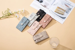 Detail of floral PU leather card holder with 5 slots and secure gold button strap