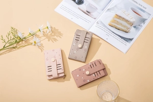 Close-up of slim floral card holders with gold zippers and multi-slot design details