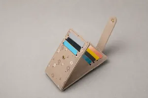 Detail view of beige floral card holder with internal multi-slot storage and snap button