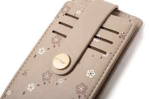 Close-up of floral print card holder showing tiered slots and golden metal snap fastener