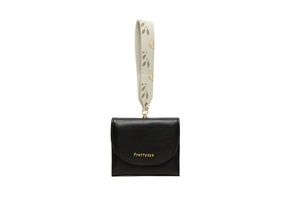 Close-up of black pebbled leather wallet with gold logo and floral printed wristlet strap