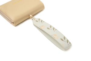 Close-up of light brown PU leather wallet with printed wrist strap and gold logo