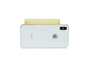 Compact yellow leather wallet shown next to an iPhone for precise size comparison
