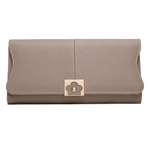 Détail du portefeuille long taupe avec surpiqûres et boucle florale dorée élégante