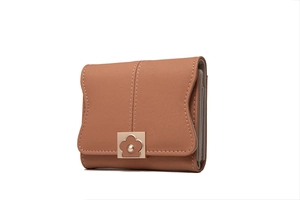 Detail of a brown trifold wallet showing white stitching and a floral metal clasp