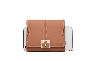 Detailed view of caramel faux leather wallet featuring flower buckle and white stitching