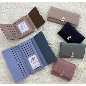 Flat lay of stylish PU leather wallets in diverse colors with golden leaf clasps
