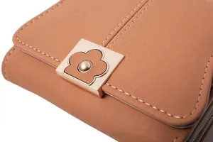 Macro view of khaki PU leather wallet detail with vintage floral metal clasp and stitching
