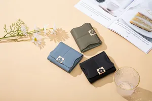 Flat lay of small PU leather wallets in blue and green with floral snap buttons
