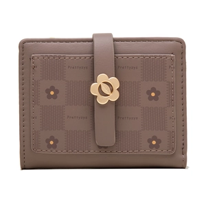 Close-up of floral gold buckle and vintage printed pattern on mocha folding wallet