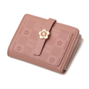 Detail of a bifold pink wallet showing floral patterns and a gold flower-shaped metal buckle