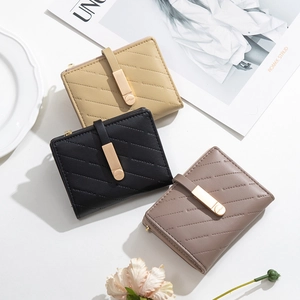 Flat lay of quilted PU leather wallets in beige, black and taupe with metal buckle