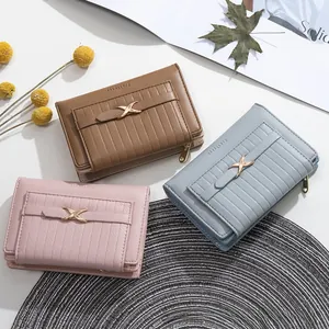 Detailed close-up of textured PU leather wallets with metallic X-buckles in various colors