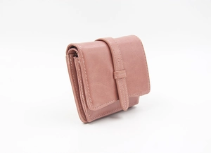 Detailed side view of a compact dusty pink tri-fold wallet with strap and snap closure