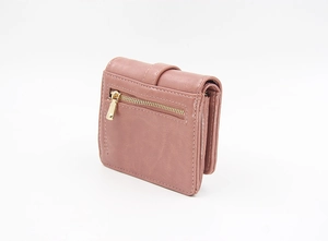 Detail of pink faux leather foldable wallet with visible golden zipper and textured surface