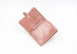 Close-up of dusty pink bifold wallet showing card slots and smooth leather texture