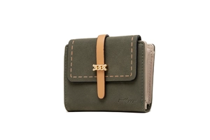 Detailed close-up of dark green suede wallet with brown strap and gold chain buckle