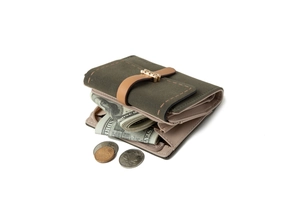 Detail view of olive green suede wallet with brown strap and multi-slot interior
