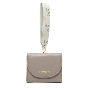 Detail of grey PU leather wallet featuring a floral strap and gold metal hardware accents