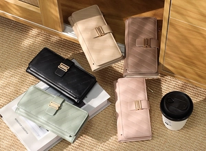 Detail showing various colors of quilted leather long wallets with chic metal buckles