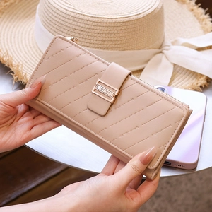 Detail of apricot striped quilted long wallet with golden buckle and multi-layer slots
