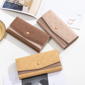 Detail of embossed floral patterns and gold rose buckles on three-fold leather wallets