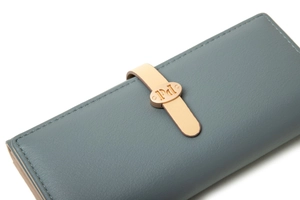 Vue détaillée du portefeuille en cuir bleu gris avec texture grainée et boucle dorée