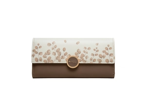 Detail of bicolored PU leather wallet with leaf print and circular gold logo buckle
