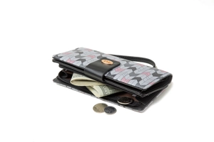 Detail of long quilted wallet showing multi-layered storage with coins and banknotes
