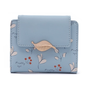 Détail du portefeuille court en similicuir bleu clair avec motifs végétaux et fermoir doré