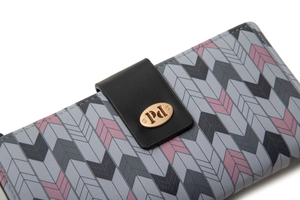 Macro view of geometric chevron pattern and gold metal logo plate on long wallet