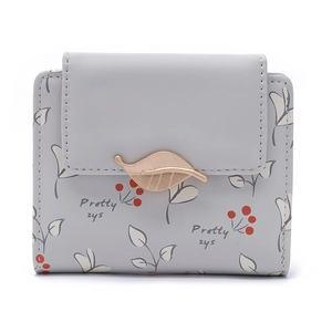 Détail du petit portefeuille gris clair à imprimé feuilles et boucle dorée élégante