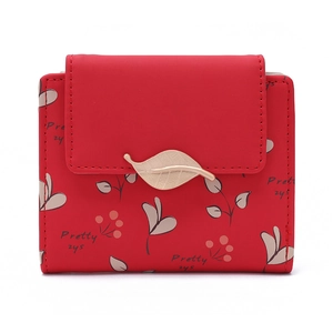 Détail du portefeuille rouge en similicuir avec imprimé feuilles et boucle dorée