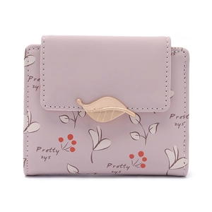 Détail du portefeuille rose en similicuir avec boucle feuille dorée et motifs floraux