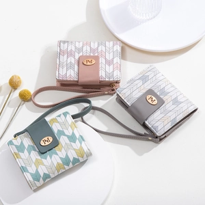 Detailed view of three-fold wallets with arrow patterns and golden metal logo buckles