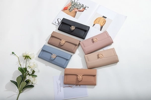 Flat lay of multiple tri-fold women's long wallets with elegant golden leaf buckle details