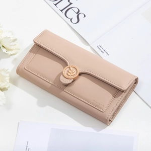 Detail view of beige leather wallet with gold leaf buckle and minimalist textures