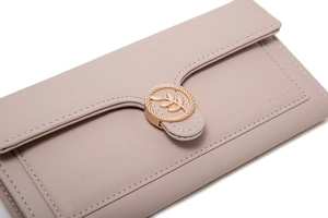 Close-up of pink long wallet featuring a rose gold leaf buckle and stitch details