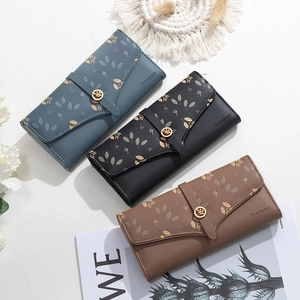 Detailed view of long wallets with leaf prints in blue, black, and brown faux leather