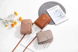 Vue détaillée de trois mini sacs bandoulière en cuir avec fermoirs papillon en métal