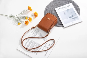 Détail du sac de téléphone en cuir PU caramel avec fermoir doré et motif litchi
