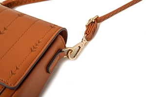 Détail de la bandoulière en cuir PU marron avec fermoir doré et broderie de feuilles