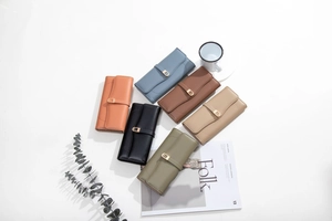 Flat lay of multiple leather wallets in various colors with elegant golden metal U-buckles