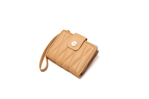 Detail of apricot wavy quilted wallet featuring a golden leaf snap button and wrist strap