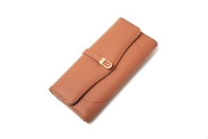 Close-up of tan leather wallet detail featuring lychee texture and gold horseshoe buckle