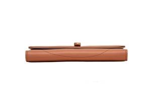 Detail view of pink leather wallet featuring layered structure and gold metal twist lock