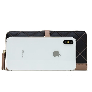 Portefeuille long en cuir matelassé noir comparé à un iPhone pour montrer les dimensions